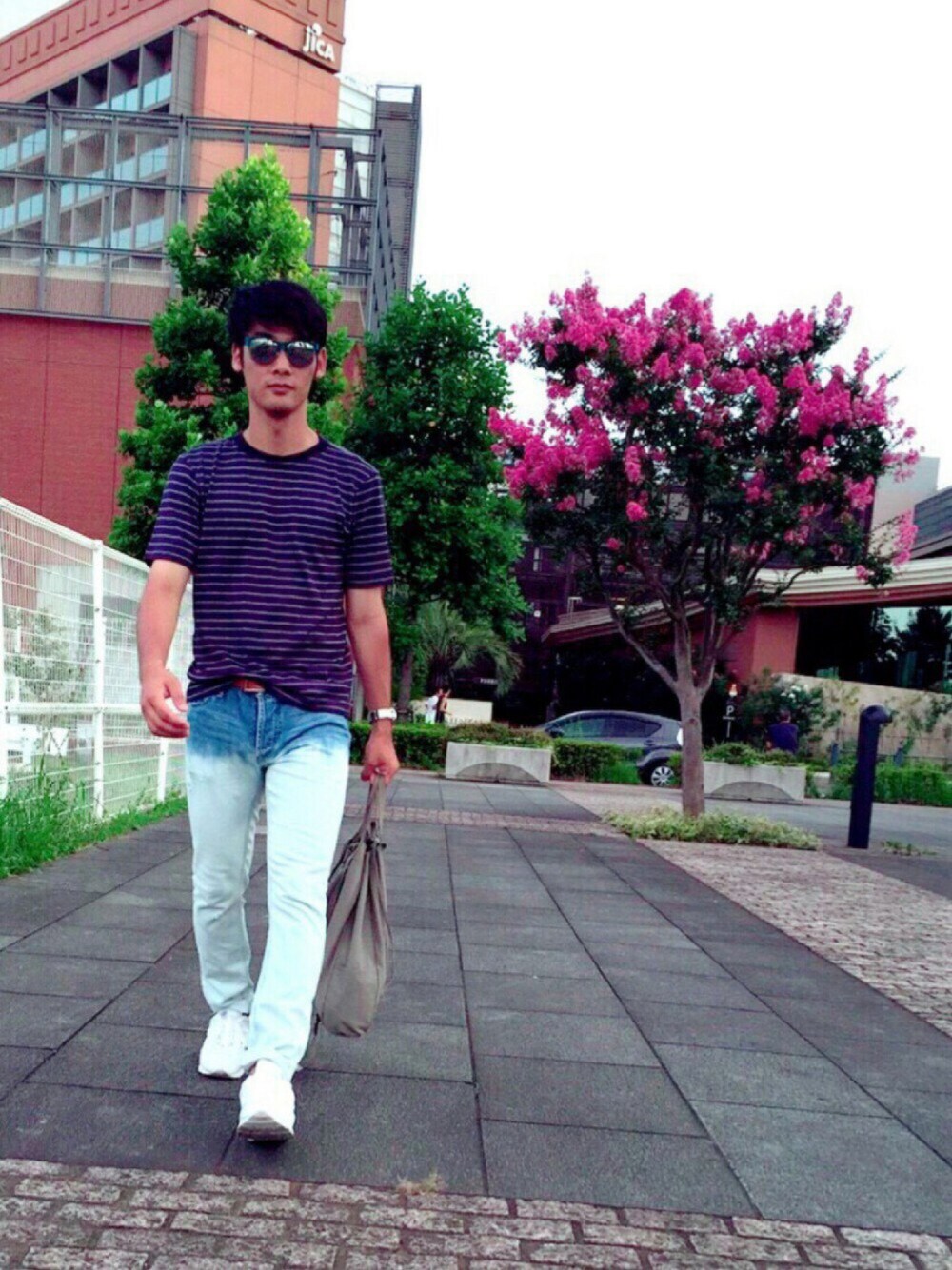 ブルー系のTシャツ/カットソー、ホワイト系のデニムパンツ、グレー系のショルダーバッグを着用したメンズの夏コーディネートの1枚目の写真