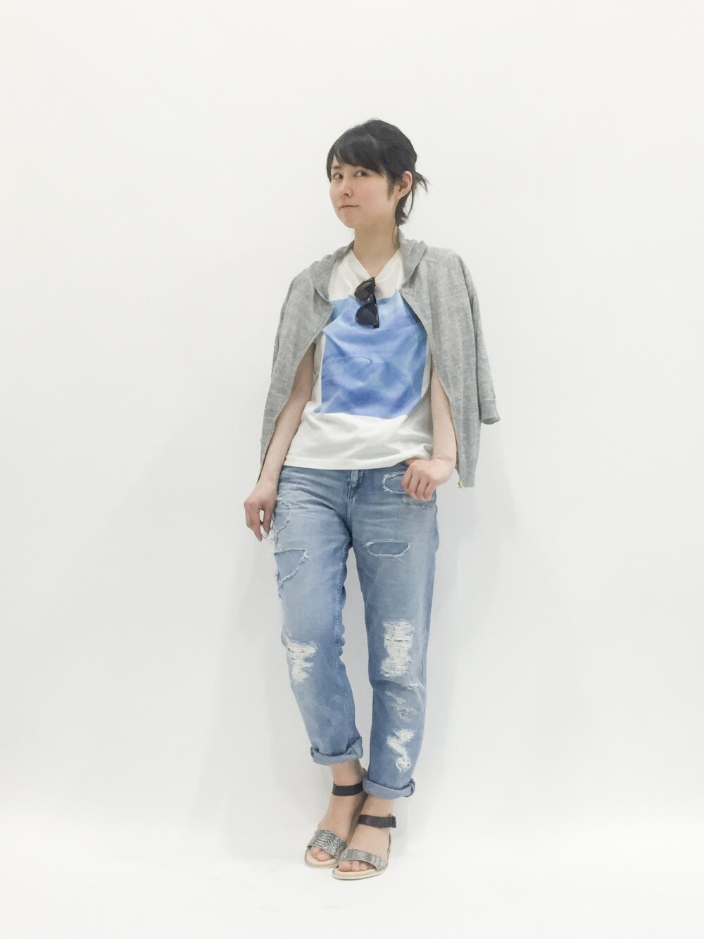 ブルー系のTシャツ/カットソー、グレー系のパーカー、ブルー系のデニムパンツを着用したレディースの春コーディネートの1枚目の写真