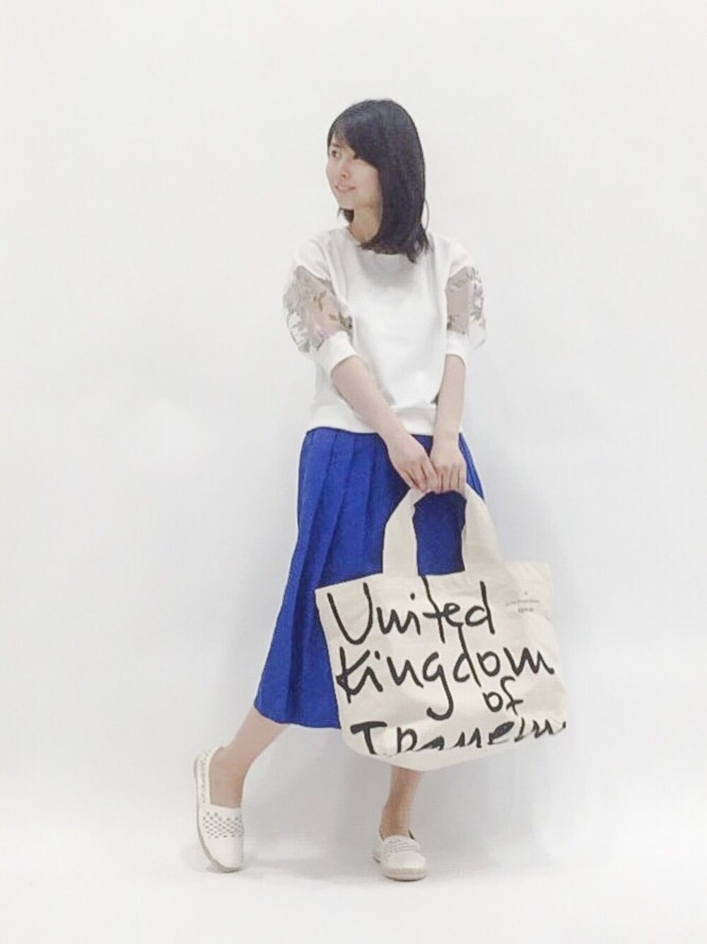 ホワイト系のスウェット、ブルー系のスカート、ホワイト系のトートバッグを着用したレディースの春コーディネートの1枚目の写真