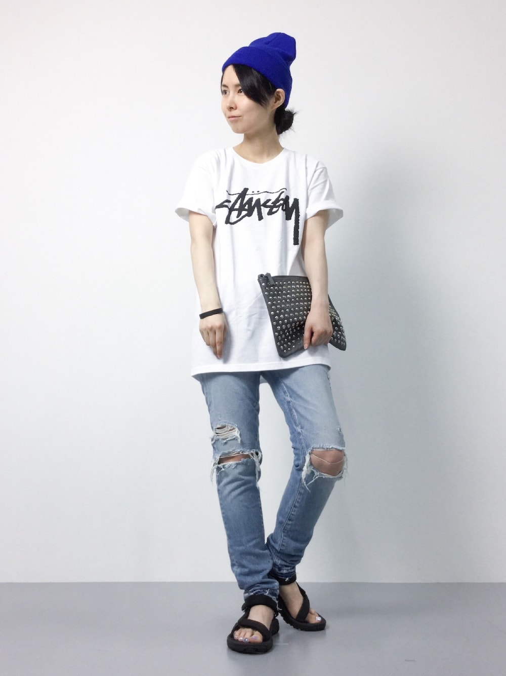 「デニム、カジュアル、stussy、ニット帽、クラッチバッグ、サンダル、パンツスタイル、ダメージデニムパンツ、白Tシャツ、スポーツサンダル」｜「Stussy WomenのStock（Tシャツ/カットソー、ホワイト系）」を使った、sayaさん（レディース・163cm）の夏コーディネートの1枚目の写真