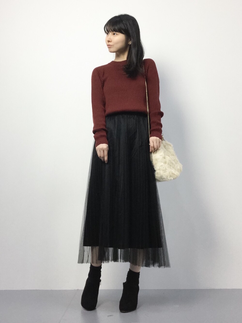 ホワイト系のショルダーバッグ、レッド系のニット/セーター、ブラック系のスカートを着用したレディースの秋コーディネートの1枚目の写真