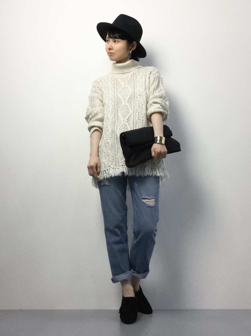 ブラック系のブーティ、ブルー系のデニムパンツ、ホワイト系のチュニックを着用したレディースの冬コーディネートの1枚目の写真