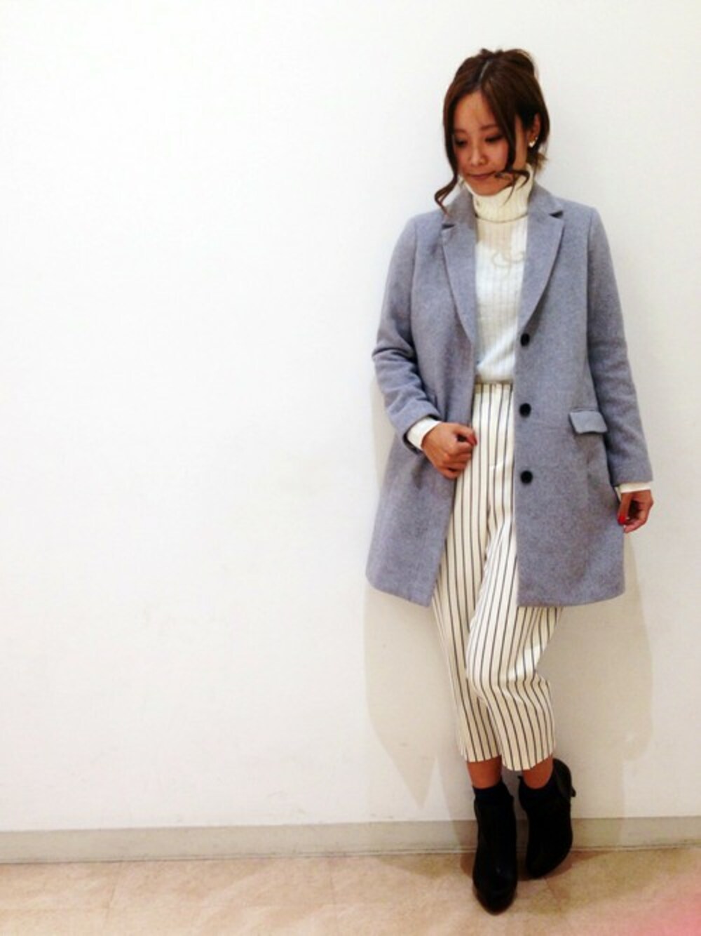 グレー系のチェスターコート、ホワイト系のニット/セーターを着用したレディースの秋コーディネートの1枚目の写真