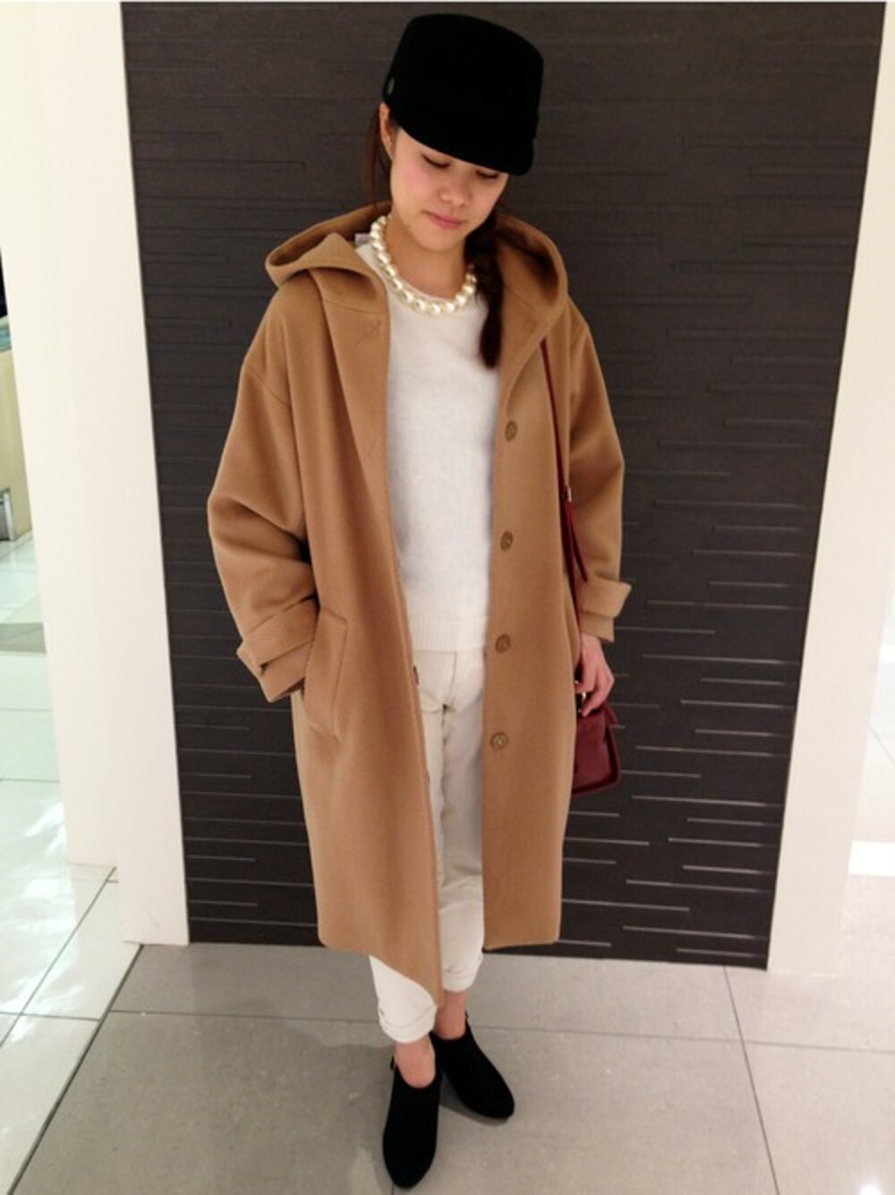 ホワイト系のニット/セーター、ブラック系のブーティを着用したレディースの秋コーディネートの1枚目の写真