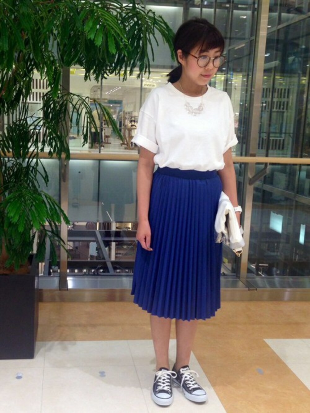 シルバー系のショルダーバッグ、ブルー系のスカート、ホワイト系のTシャツ/カットソーを着用したレディースの春コーディネートの1枚目の写真