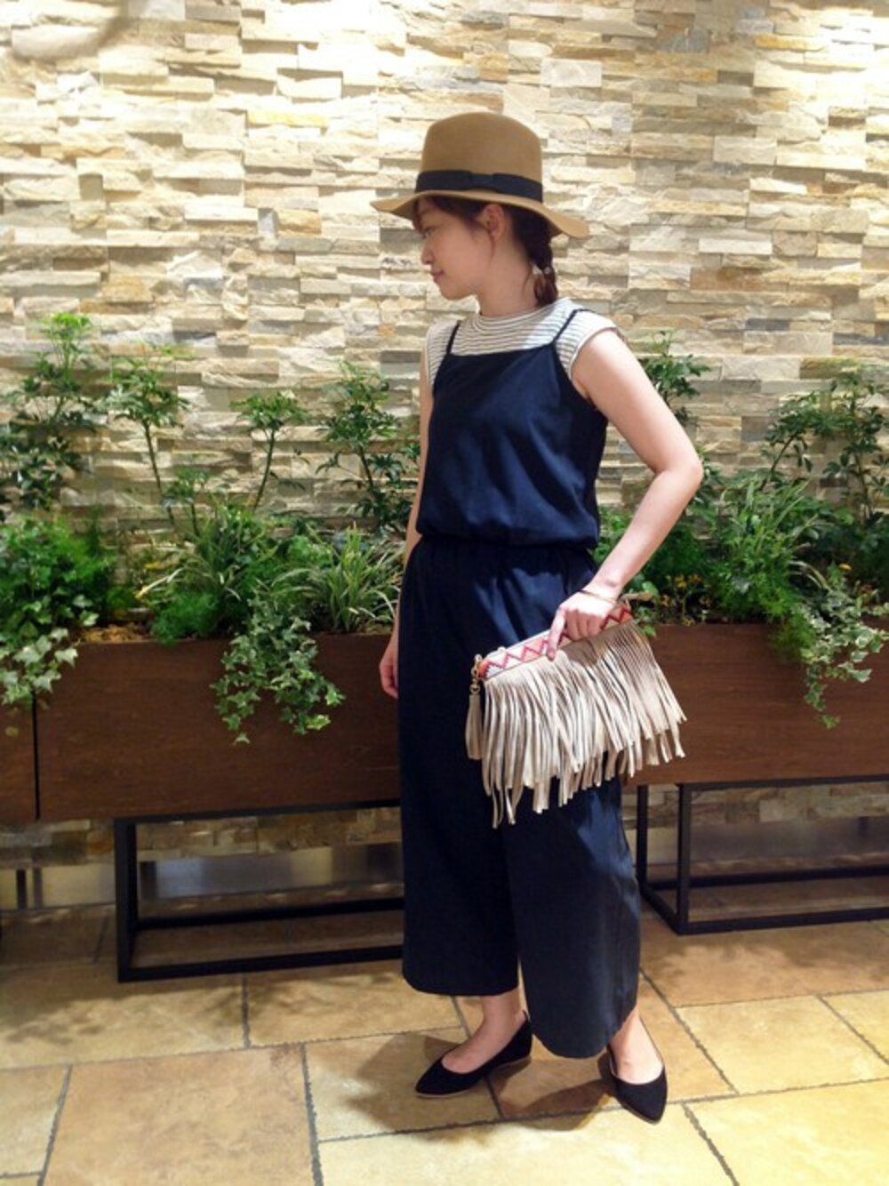 ブルー系のつなぎ/オールインワン、ホワイト系のタンクトップ、ベージュ系のクラッチバッグを着用したレディースの夏コーディネートの1枚目の写真