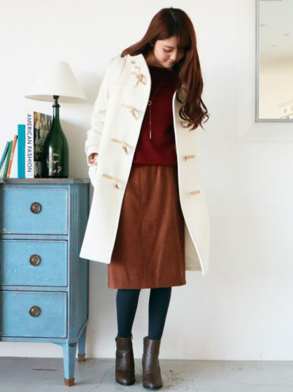 ホワイト系のダッフルコート、レッド系のニット/セーター、ブラウン系のスカートを着用したレディースの秋コーディネートの1枚目の写真