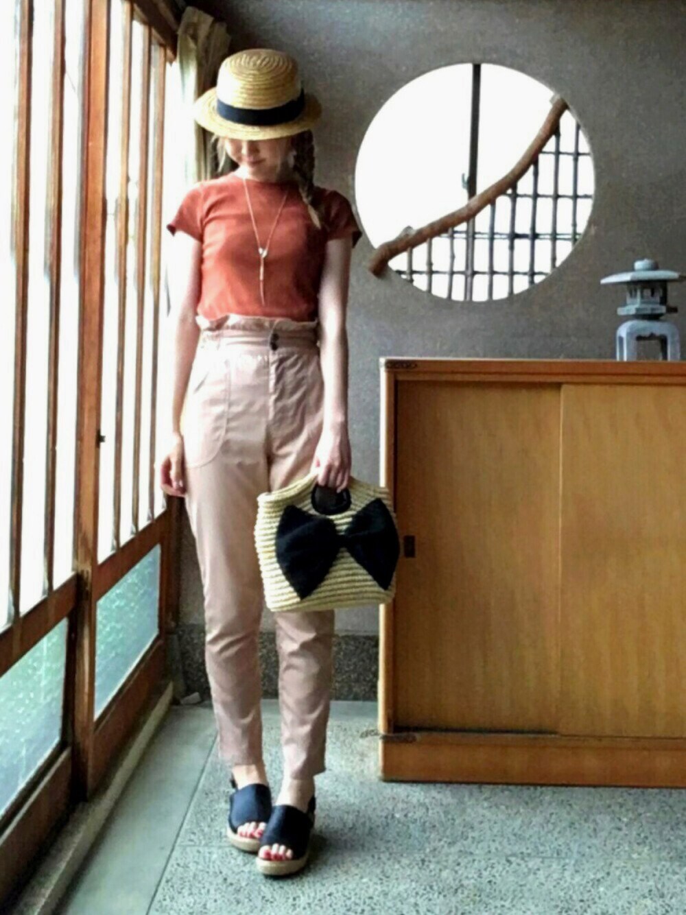 ベージュ系のその他パンツ、ブラウン系のトップス、ブラック系のかごバッグを着用したレディースの夏コーディネートの1枚目の写真