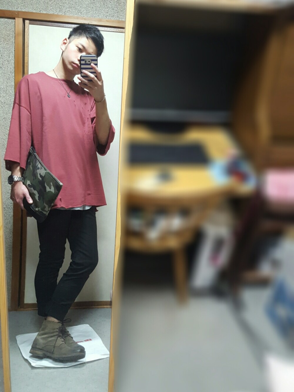 グリーン系のクラッチバッグ、レッド系のTシャツ/カットソー、ブラック系のその他パンツを着用したメンズの秋コーディネートの1枚目の写真