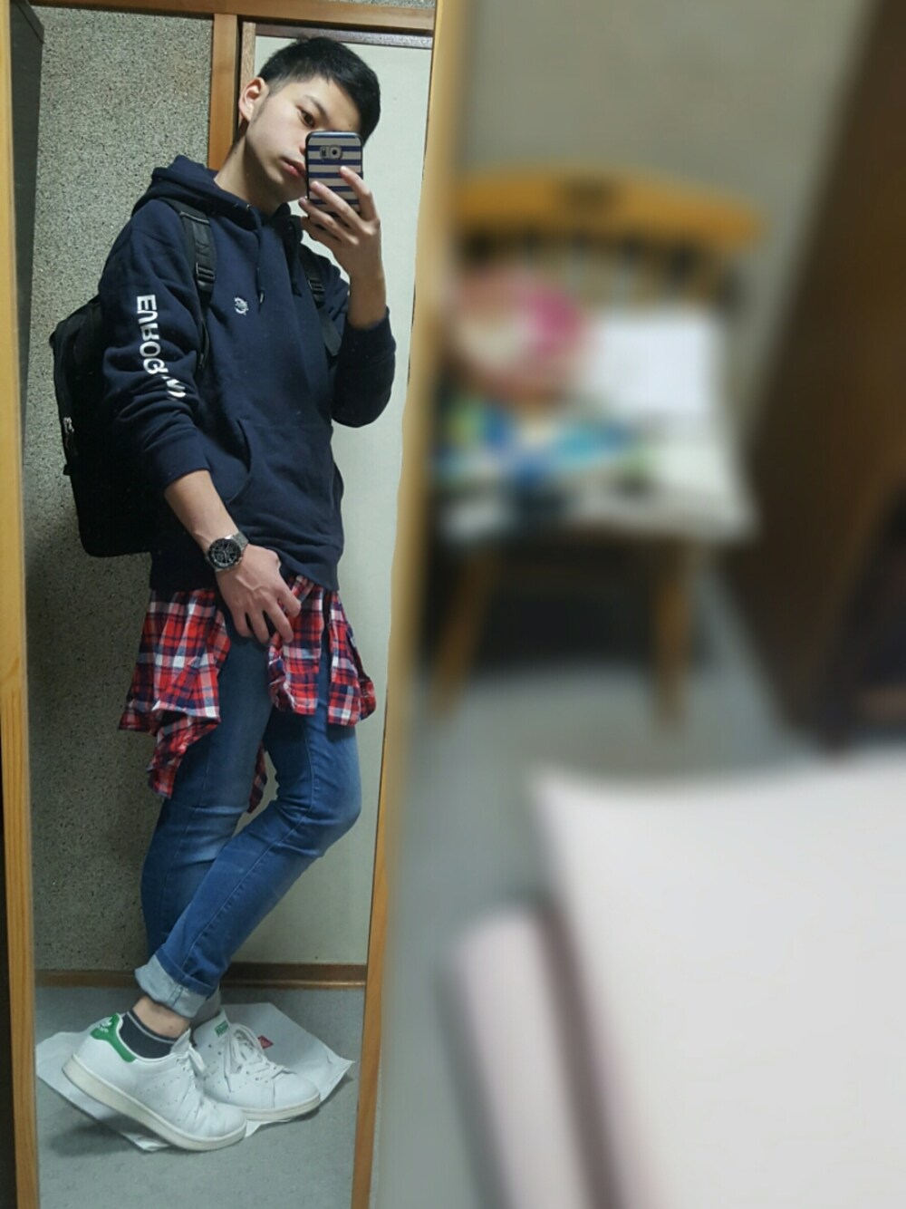 ホワイト系のスニーカー、レッド系のシャツ/ブラウス、ブルー系のデニムパンツを着用したメンズの秋コーディネートの1枚目の写真