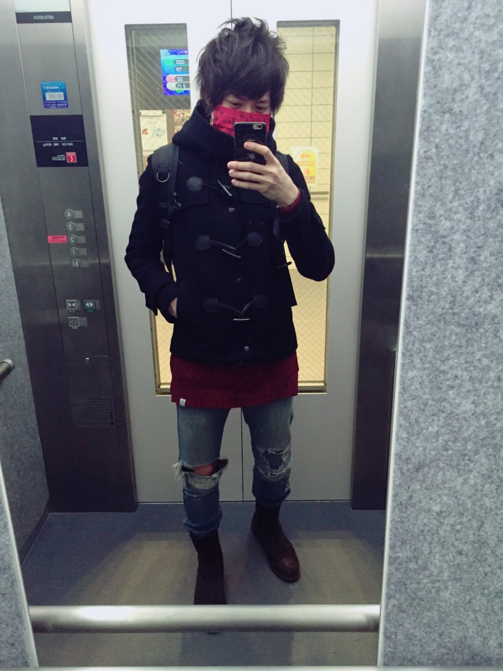 ブラウン系のブーツ、ブラック系のダッフルコート、レッド系のニット/セーターを着用したメンズの冬コーディネートの1枚目の写真