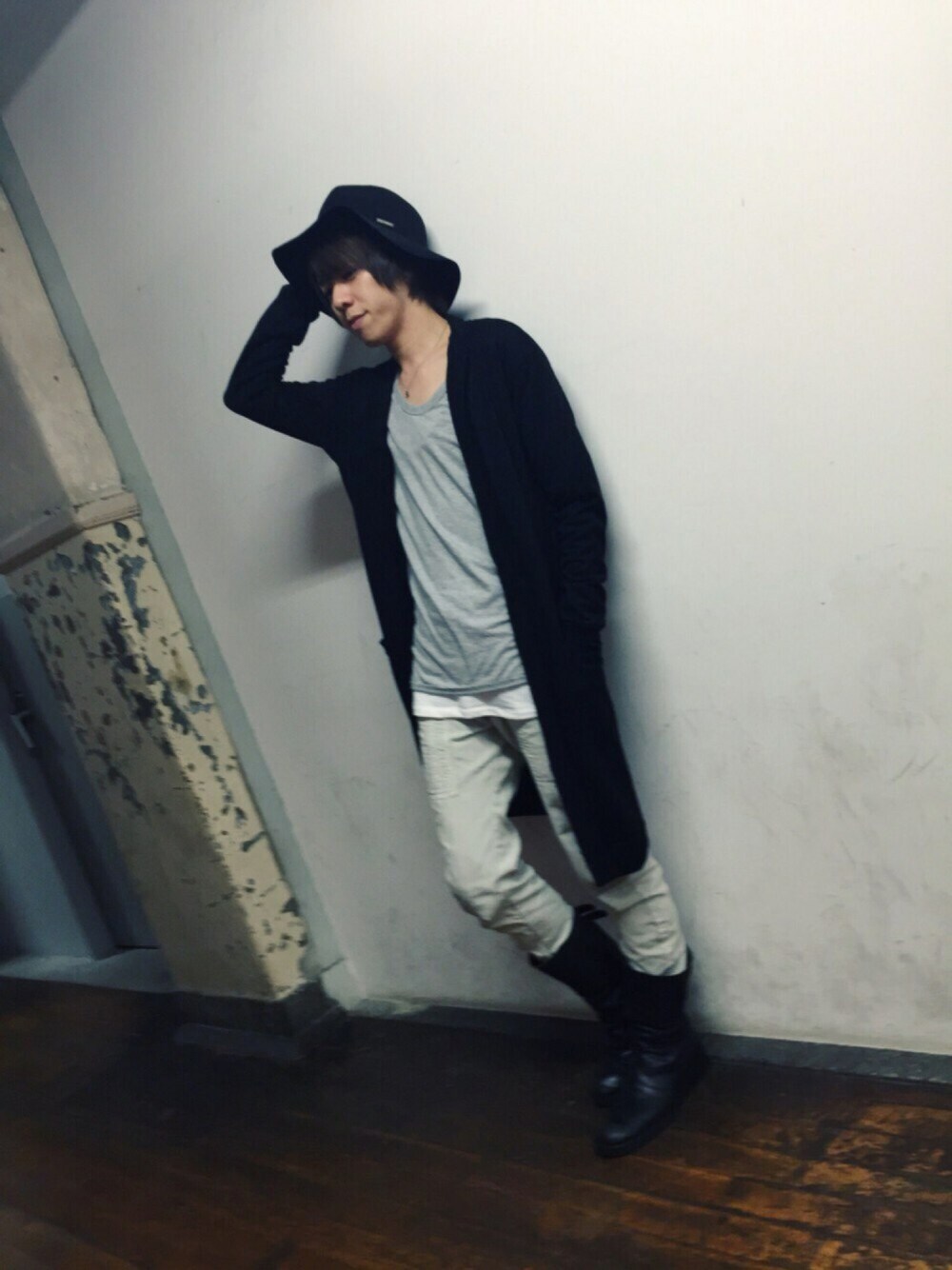 グレー系のカーディガン/ボレロ、ブラック系のブーツ、グレー系のパンツを着用したメンズの春コーディネートの1枚目の写真