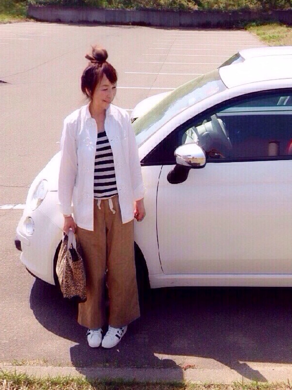 グリーン系のチノパンツ、ホワイト系のスニーカー、その他のトートバッグを着用したレディースの春コーディネートの1枚目の写真