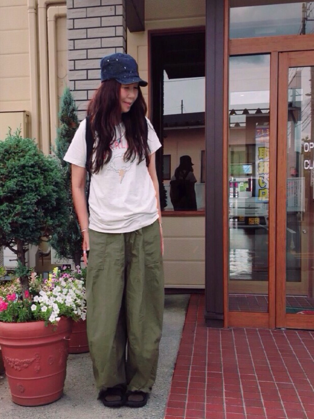 ホワイト系のTシャツ/カットソー、ブラック系のバックパック/リュック、グリーン系のその他パンツを着用したレディースの夏コーディネートの1枚目の写真