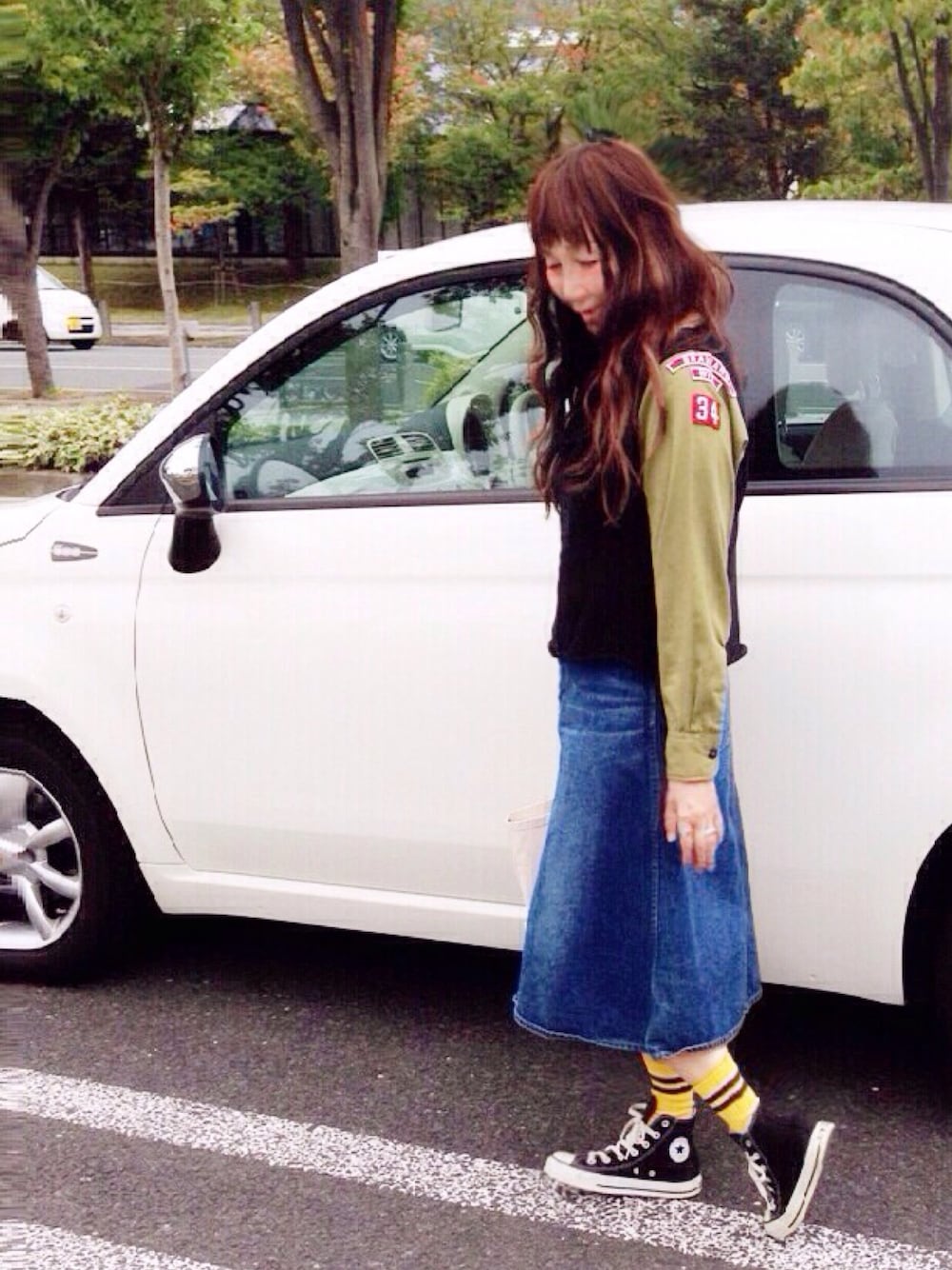 ブルー系のデニムスカート、ブラック系のスニーカー、ホワイト系のトートバッグを着用したレディースの秋コーディネートの1枚目の写真