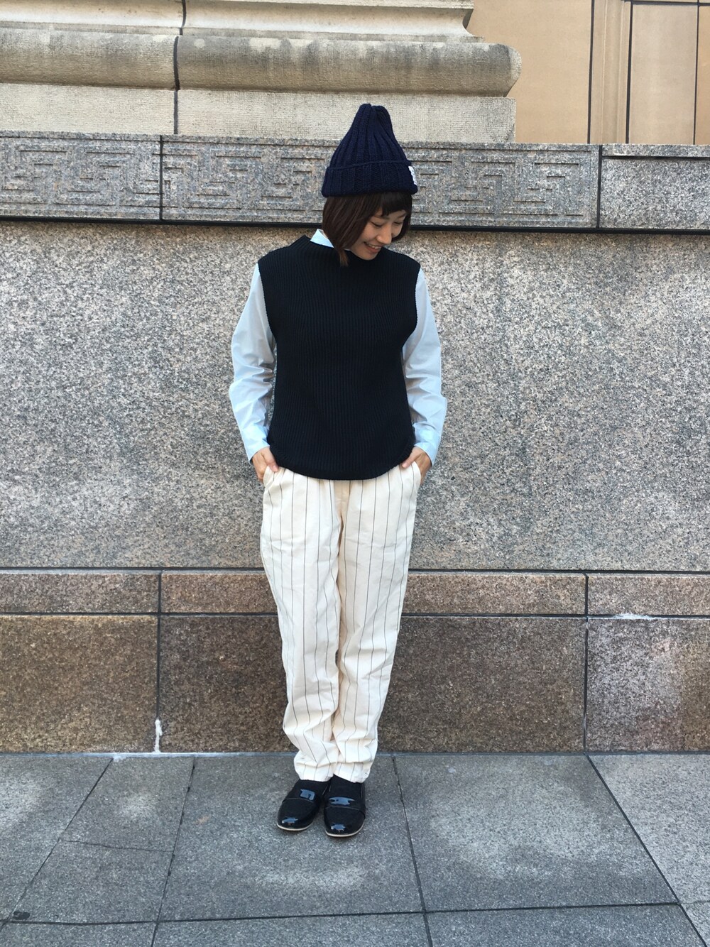 ブラック系のニット/セーター、ブルー系のシャツ/ブラウス、ブラック系のローファーを着用したレディースの秋コーディネートの1枚目の写真