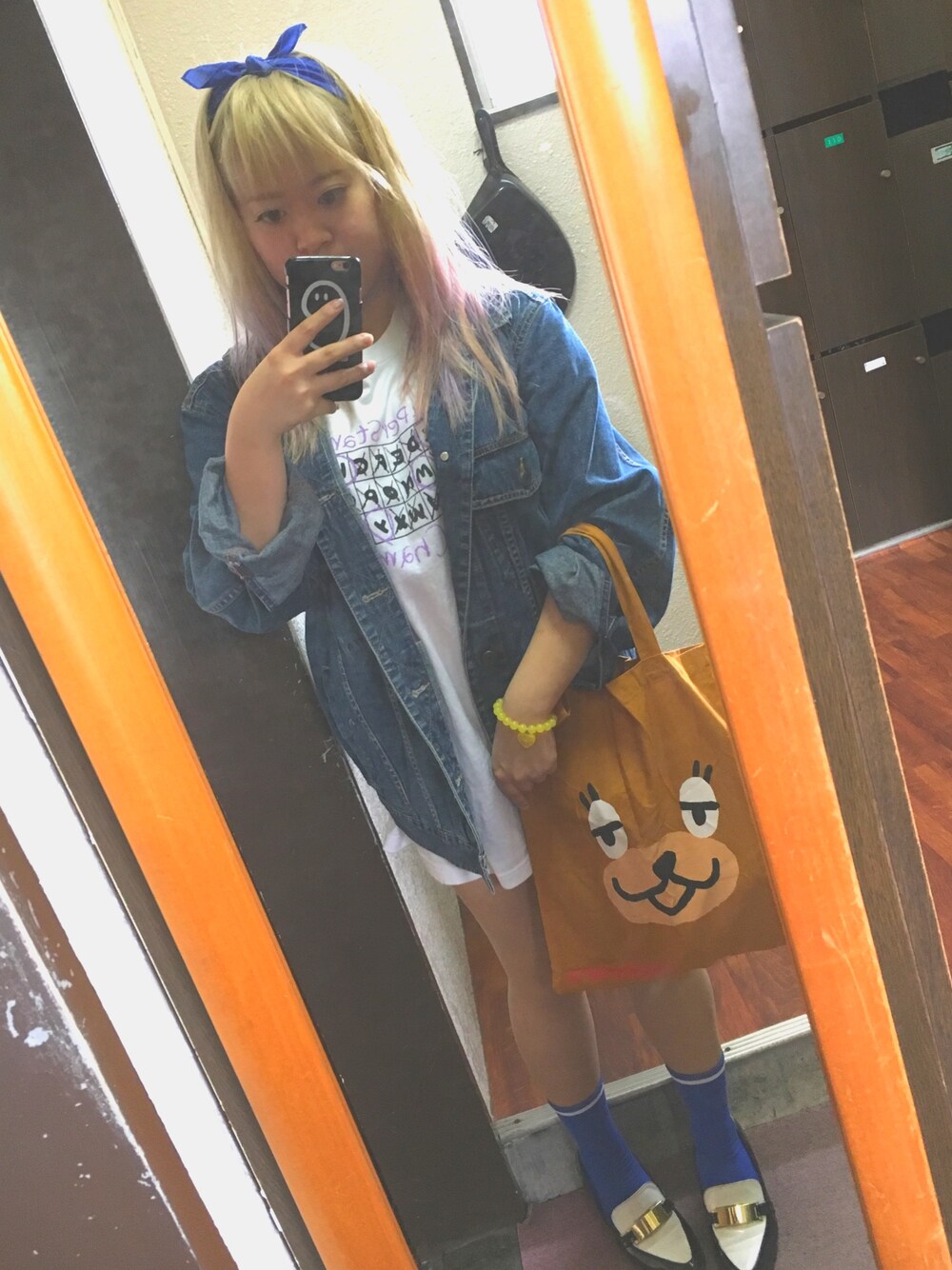 ブラウン系のトートバッグ、ブルー系のデニムジャケット、ホワイト系のTシャツ/カットソーを着用したレディースの春コーディネートの1枚目の写真