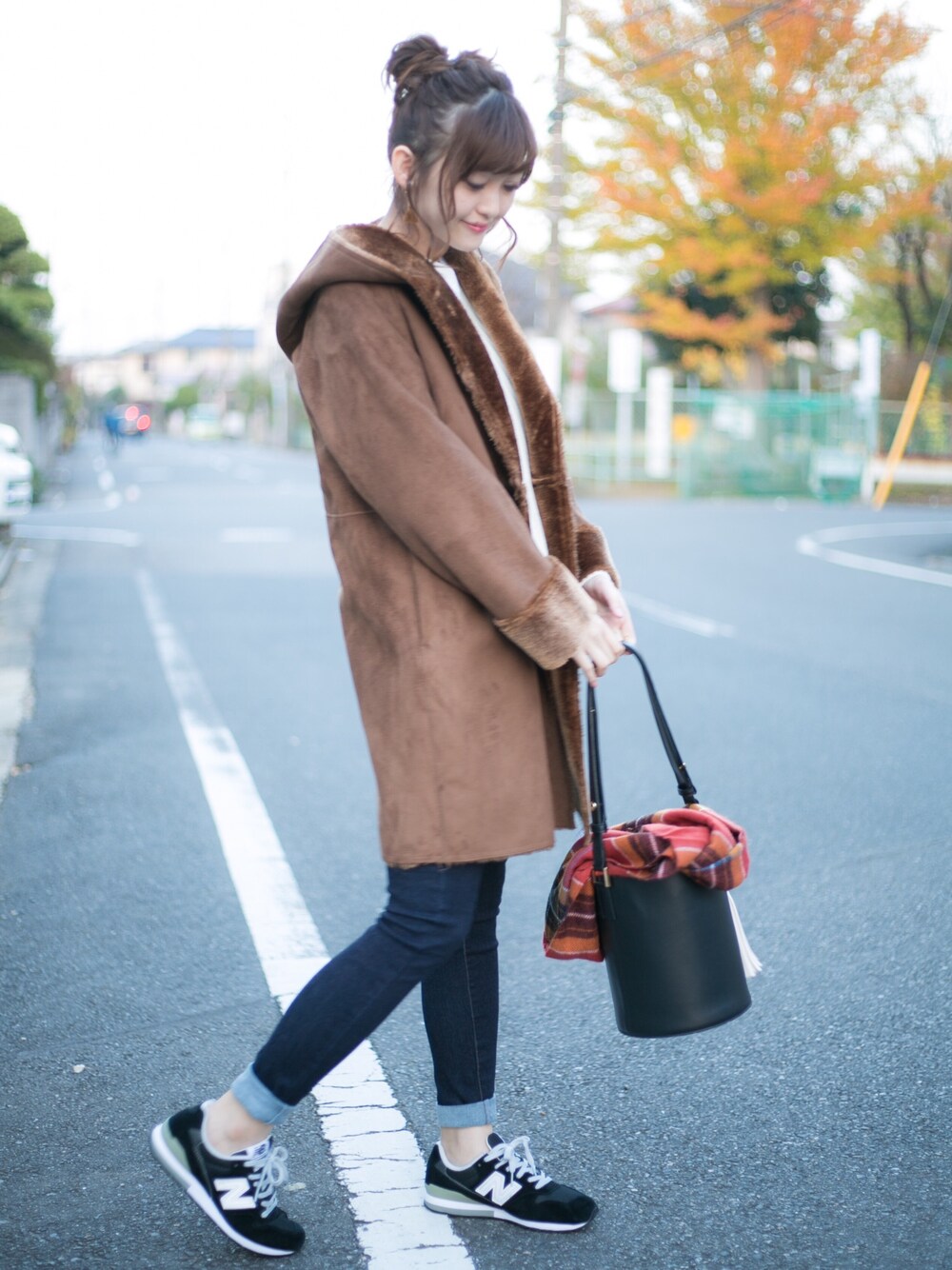グリーン系のニット/セーター、ブルー系のデニムパンツ、ブラウン系のムートンコートを着用したレディースの秋コーディネートの1枚目の写真