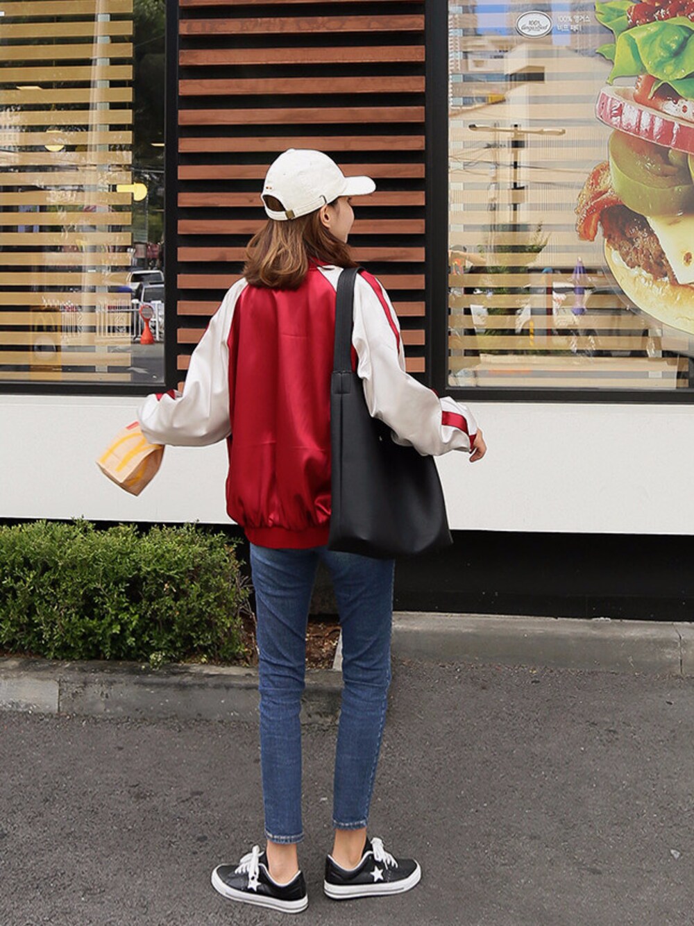 レッド系のスタジャンを着用したレディースの秋コーディネートの1枚目の写真