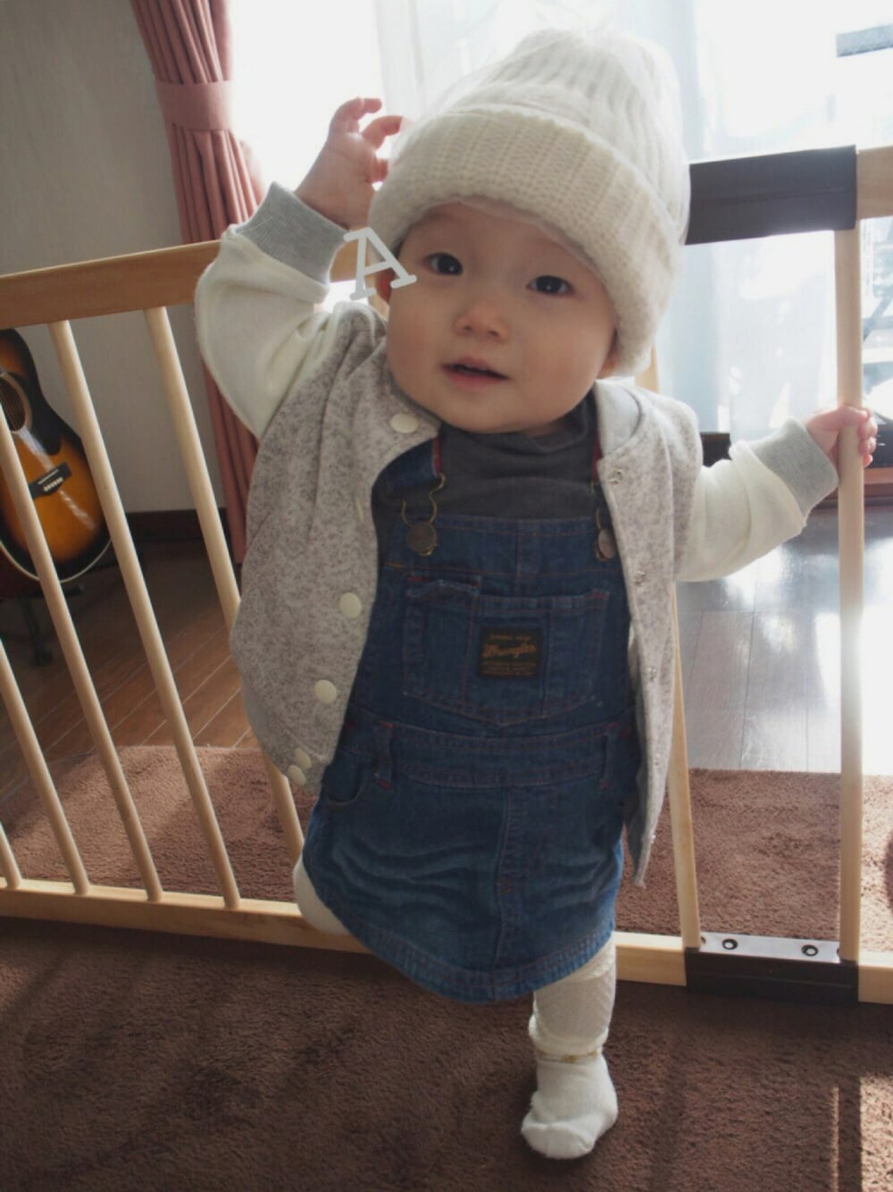 グレー系のTシャツ/カットソー、ブルー系のサロペット/オーバーオール、ホワイト系のニットキャップ/ビーニーを着用したキッズの冬コーディネートの1枚目の写真