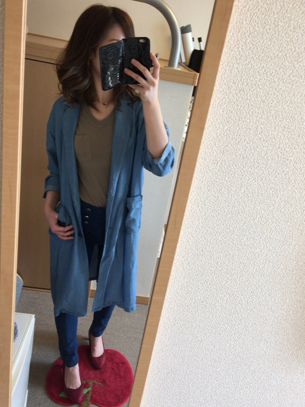 レッド系のパンプス、ブルー系のチェスターコート、グリーン系のTシャツ/カットソーを着用したレディースの秋コーディネートの1枚目の写真