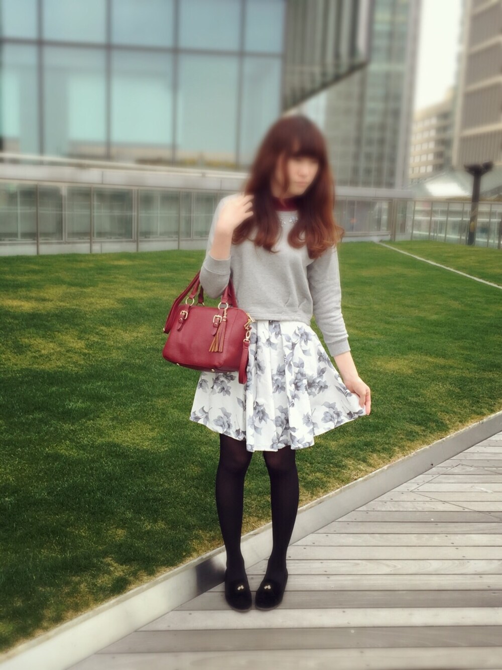 グレー系のトップス、ホワイト系のスカート、ブラック系のパンプスを着用したレディースの冬コーディネートの1枚目の写真