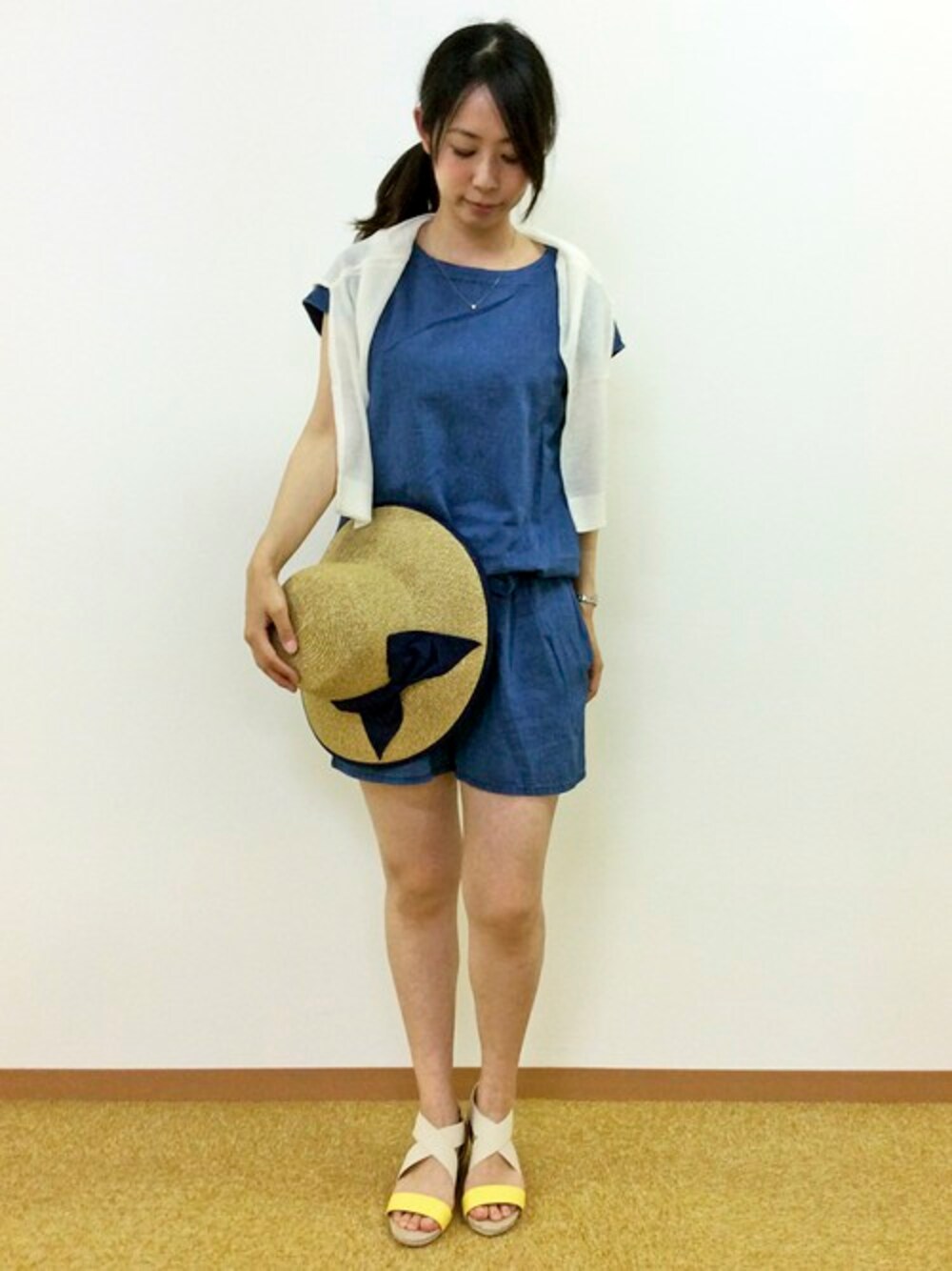 ブルー系のサロペット/オーバーオール、ホワイト系のカーディガン/ボレロ、イエロー系のサンダルを着用したレディースの夏コーディネートの1枚目の写真