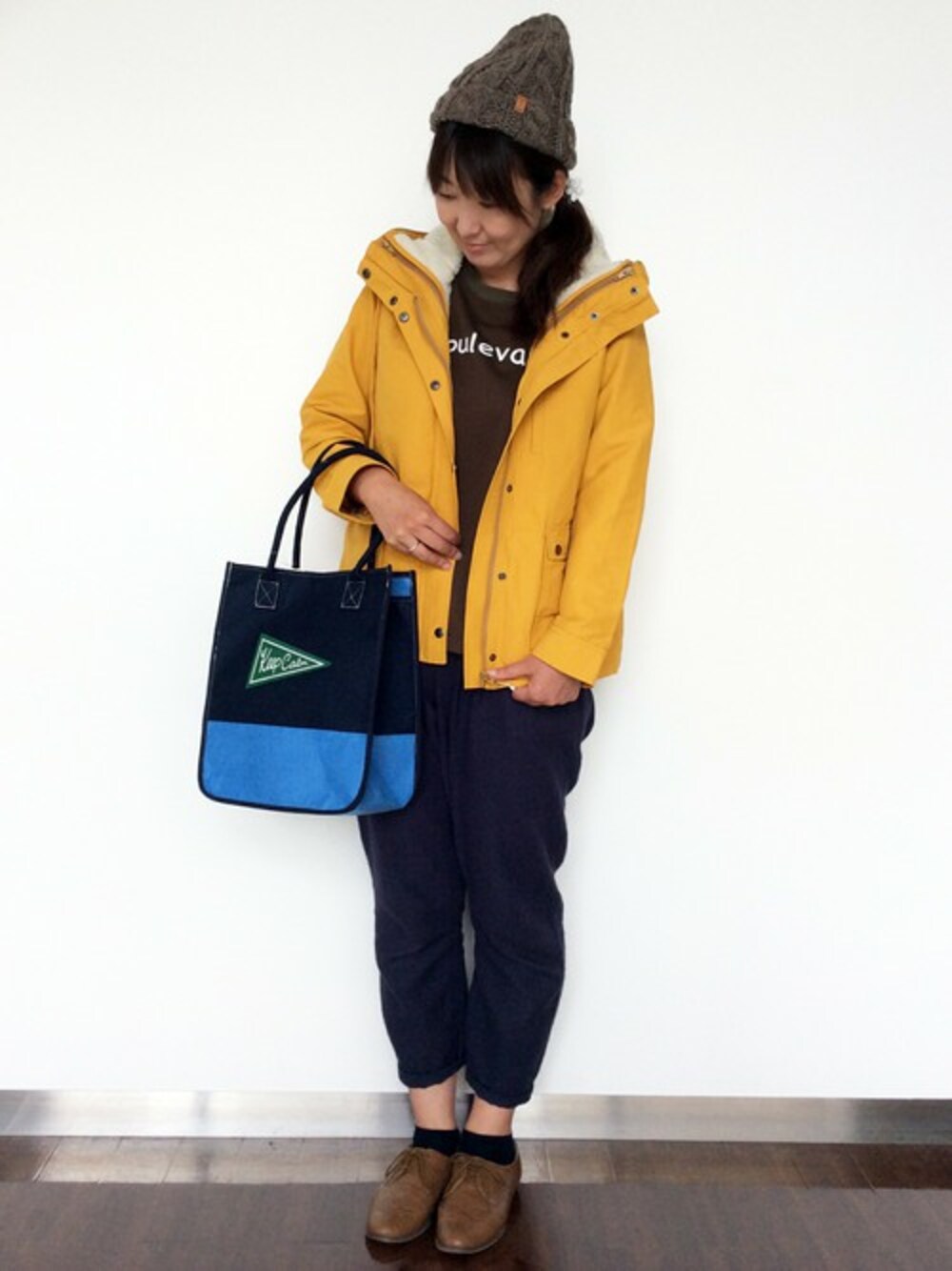 イエロー系のマウンテンパーカー、グリーン系のTシャツ/カットソー、ブルー系のその他パンツを着用したレディースの秋コーディネートの1枚目の写真