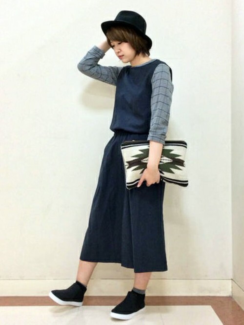 グレー系のシャツ/ブラウス、ブルー系のサロペット/オーバーオール、ブラック系のスニーカーを着用したレディースの秋コーディネートの1枚目の写真