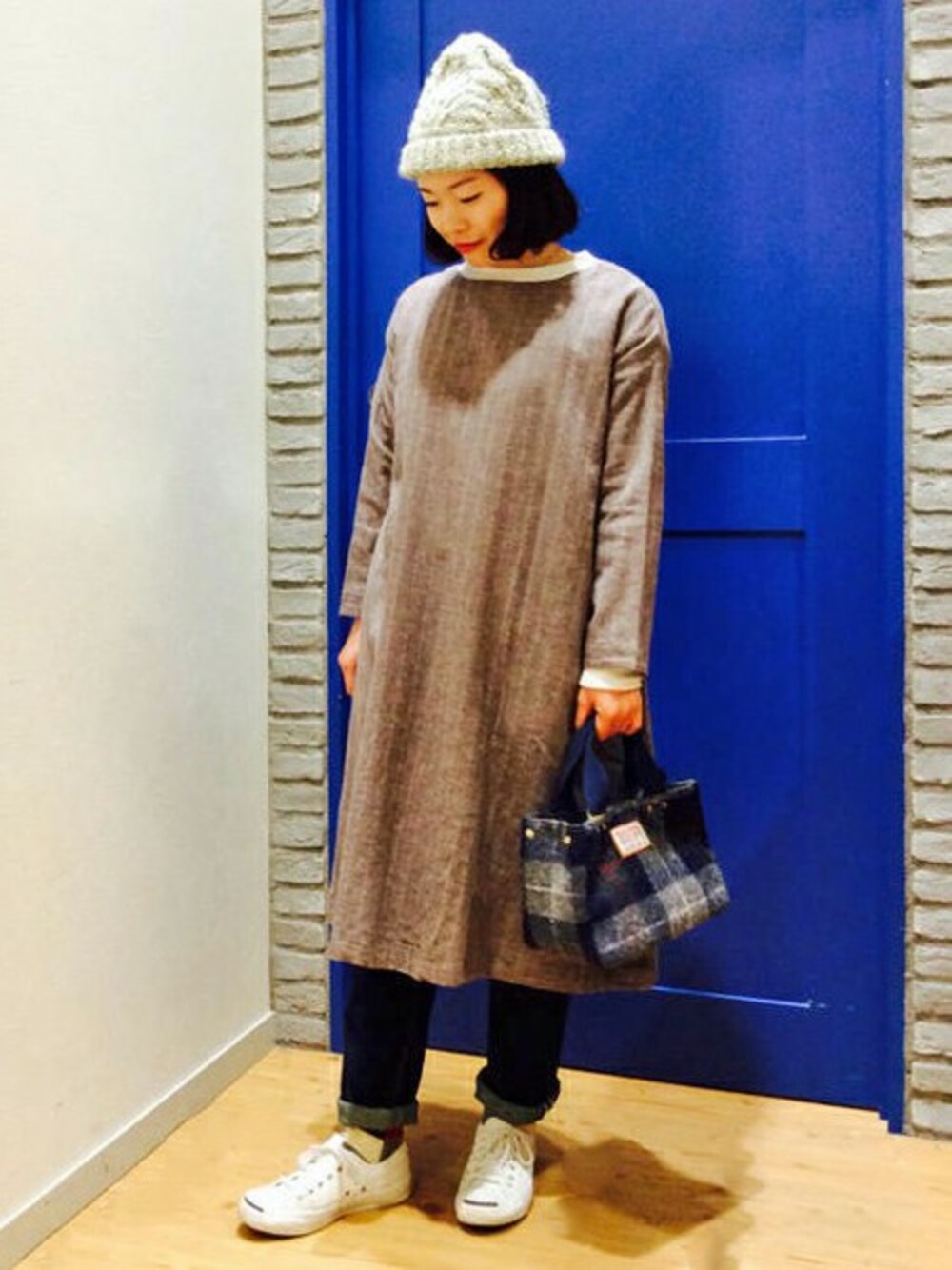 ブラウン系のワンピース、ブルー系のデニムパンツ、ホワイト系のTシャツ/カットソーを着用したレディースの冬コーディネートの1枚目の写真