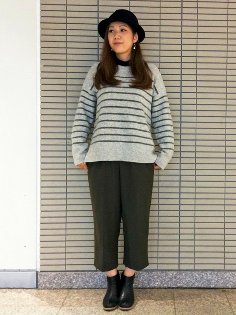 グリーン系のその他パンツ、グレー系のニット/セーター、ブラック系のTシャツ/カットソーを着用したレディースの冬コーディネートの1枚目の写真