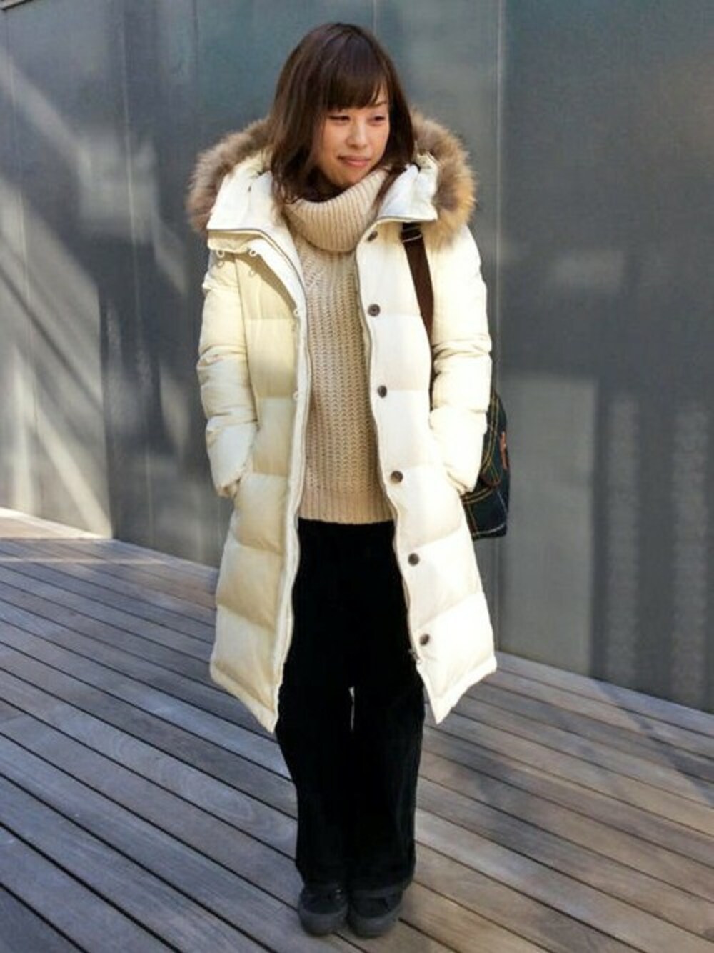 ホワイト系のダウンジャケット/コート、ベージュ系のニット/セーター、ブルー系のその他パンツを着用したレディースの冬コーディネートの1枚目の写真