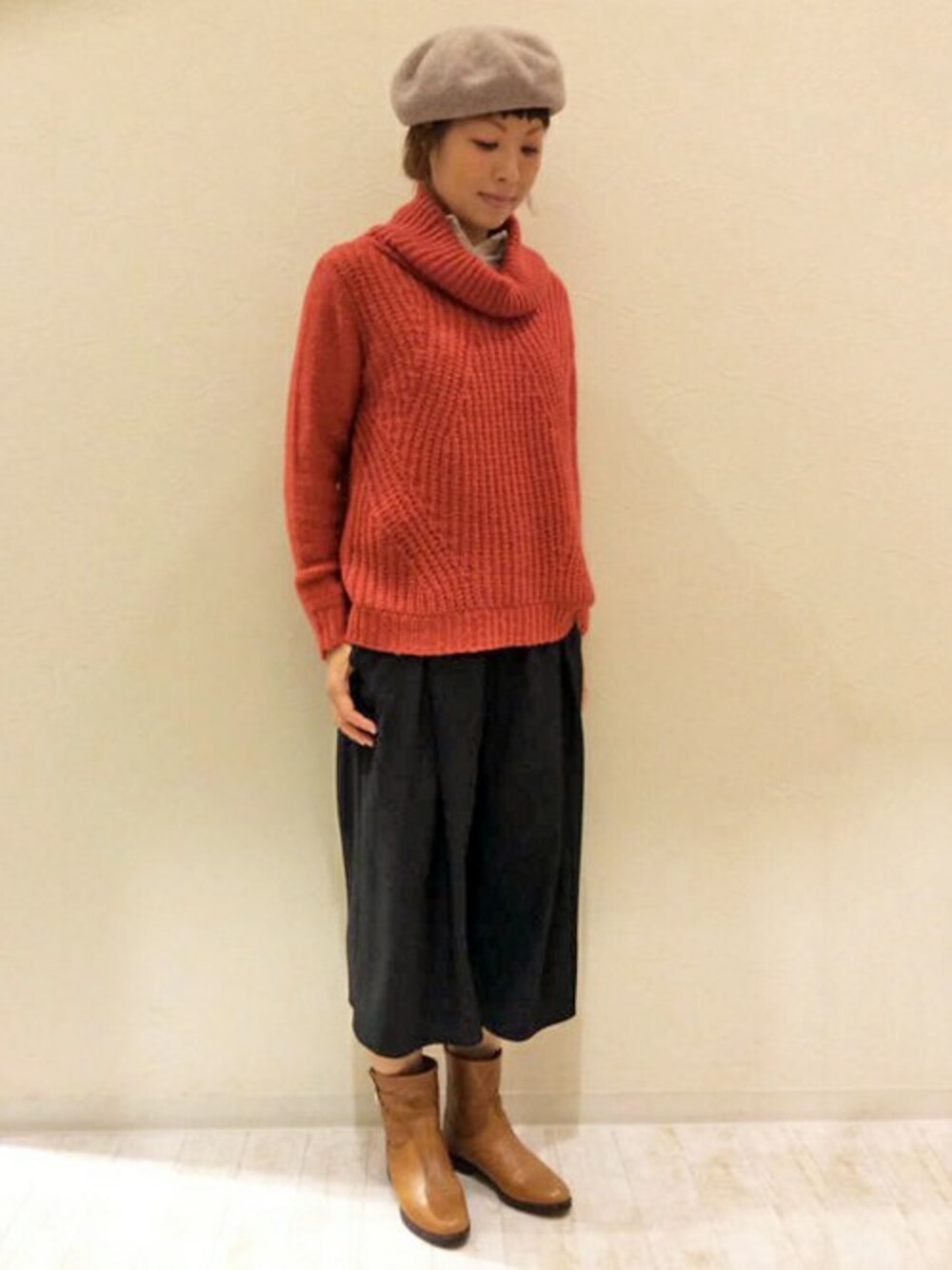 レッド系のニット/セーター、ブラック系のその他パンツ、ベージュ系のハンチング/ベレー帽を着用したレディースの冬コーディネートの1枚目の写真