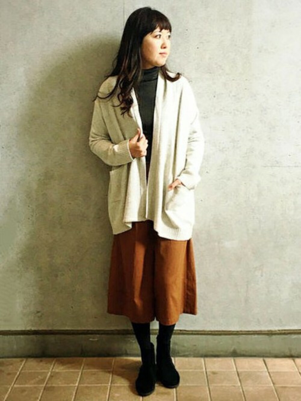 ブラウン系のその他パンツ、グレー系のニット/セーター、ホワイト系のカーディガン/ボレロを着用したレディースの冬コーディネートの1枚目の写真