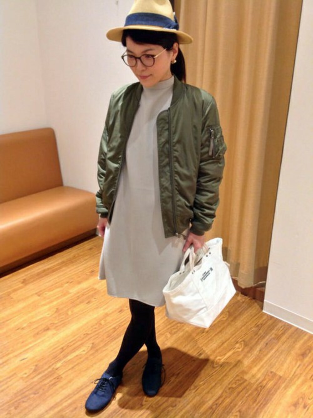 グリーン系のMA-1、グレー系のワンピース、ホワイト系のトートバッグを着用したレディースの冬コーディネートの1枚目の写真