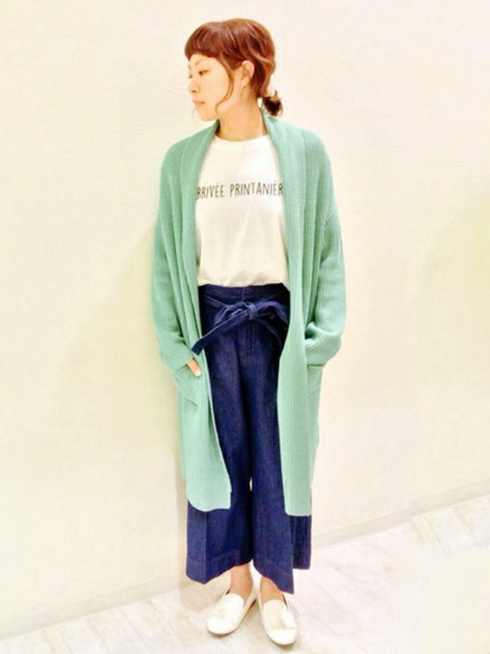 グリーン系のカーディガン/ボレロ、ホワイト系のTシャツ/カットソー、ブルー系のデニムパンツを着用したレディースの冬コーディネートの1枚目の写真