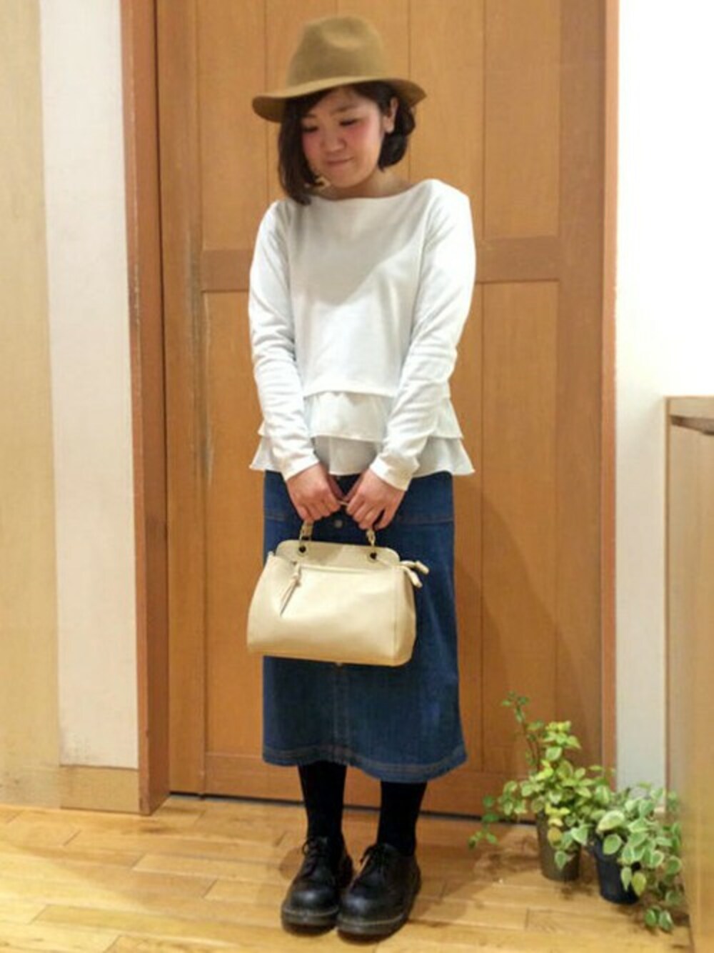 ホワイト系のTシャツ/カットソー、ブルー系のデニムスカート、ホワイト系のショルダーバッグを着用したレディースの冬コーディネートの1枚目の写真