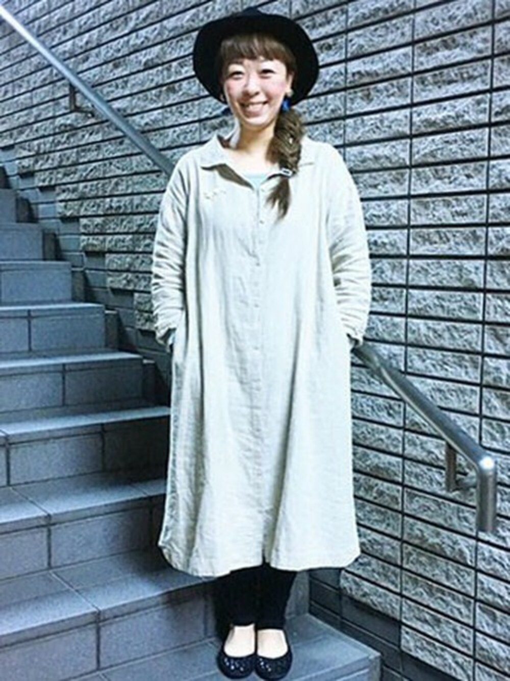 ベージュ系のシャツワンピース、ブラック系のハットを着用したレディースの冬コーディネートの1枚目の写真