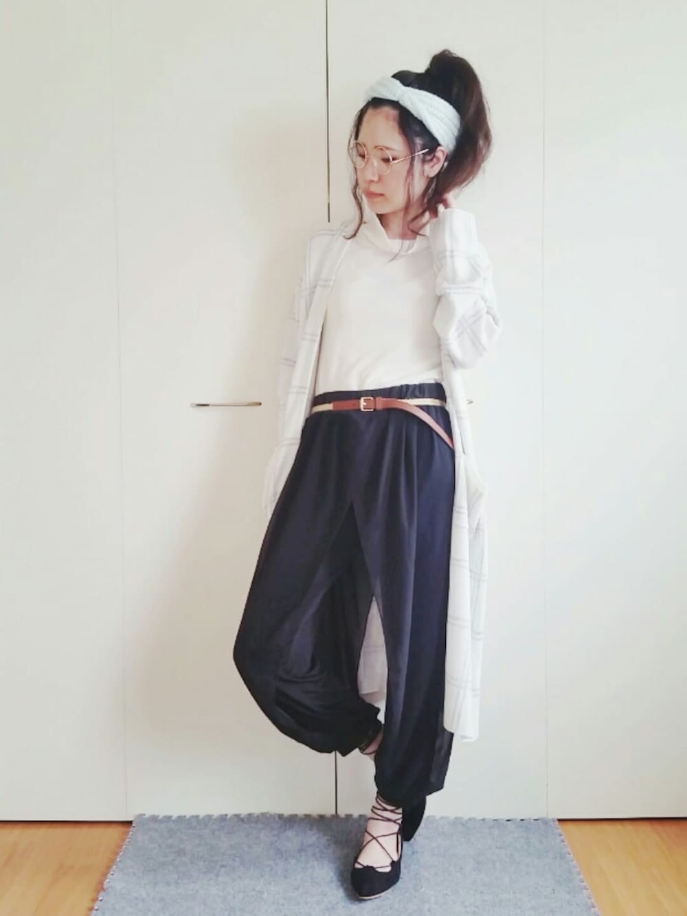 ブラック系のパンツ、ホワイト系のカーディガン/ボレロ、ブラック系のパンプスを着用したレディースの春コーディネートの1枚目の写真