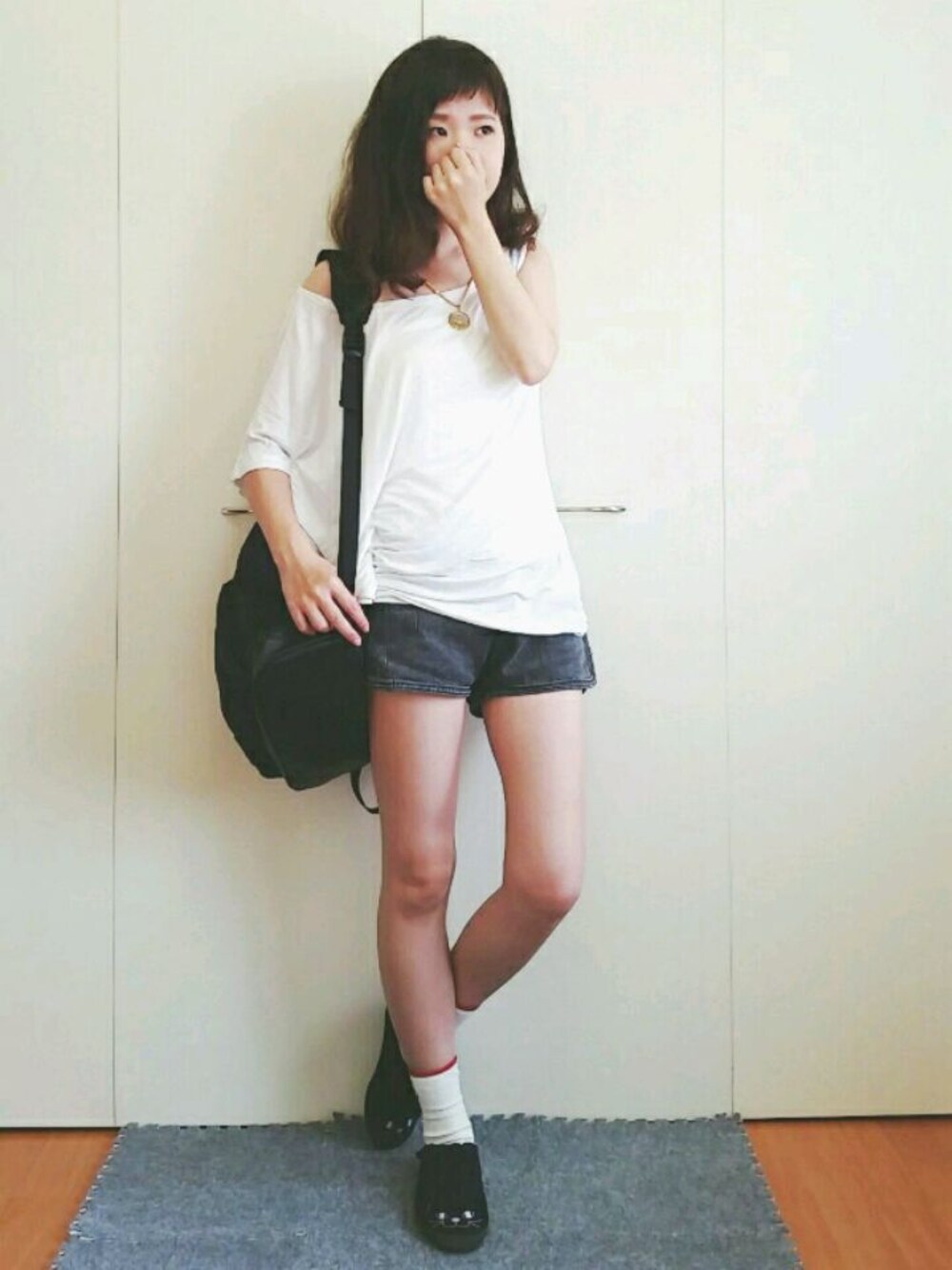 ブラック系のデニムパンツ、ホワイト系のTシャツ/カットソー、ブラック系のバックパック/リュックを着用したレディースの秋コーディネートの1枚目の写真