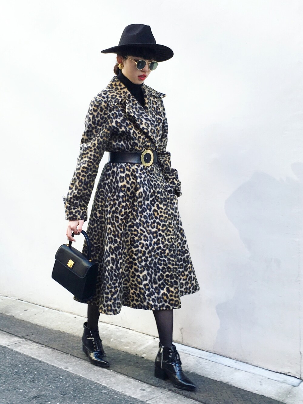 ブラック系のハンドバッグ、ブラック系のブーツ、ブラウン系のチェスターコートを着用したレディースの冬コーディネートの1枚目の写真