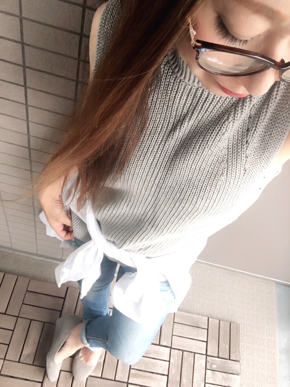 グレー系のニット/セーター、ホワイト系のシャツ/ブラウス、ブルー系のデニムパンツを着用したレディースの夏コーディネートの1枚目の写真