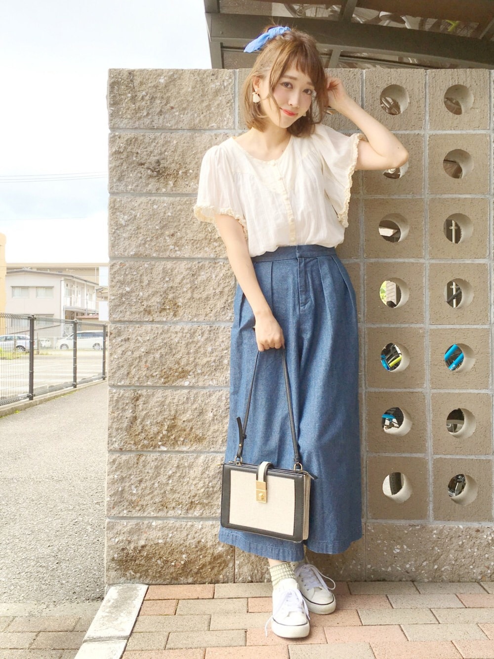 ブルー系のデニムパンツ、ホワイト系のシャツ/ブラウス、ホワイト系のスニーカーを着用したレディースの春コーディネートの1枚目の写真