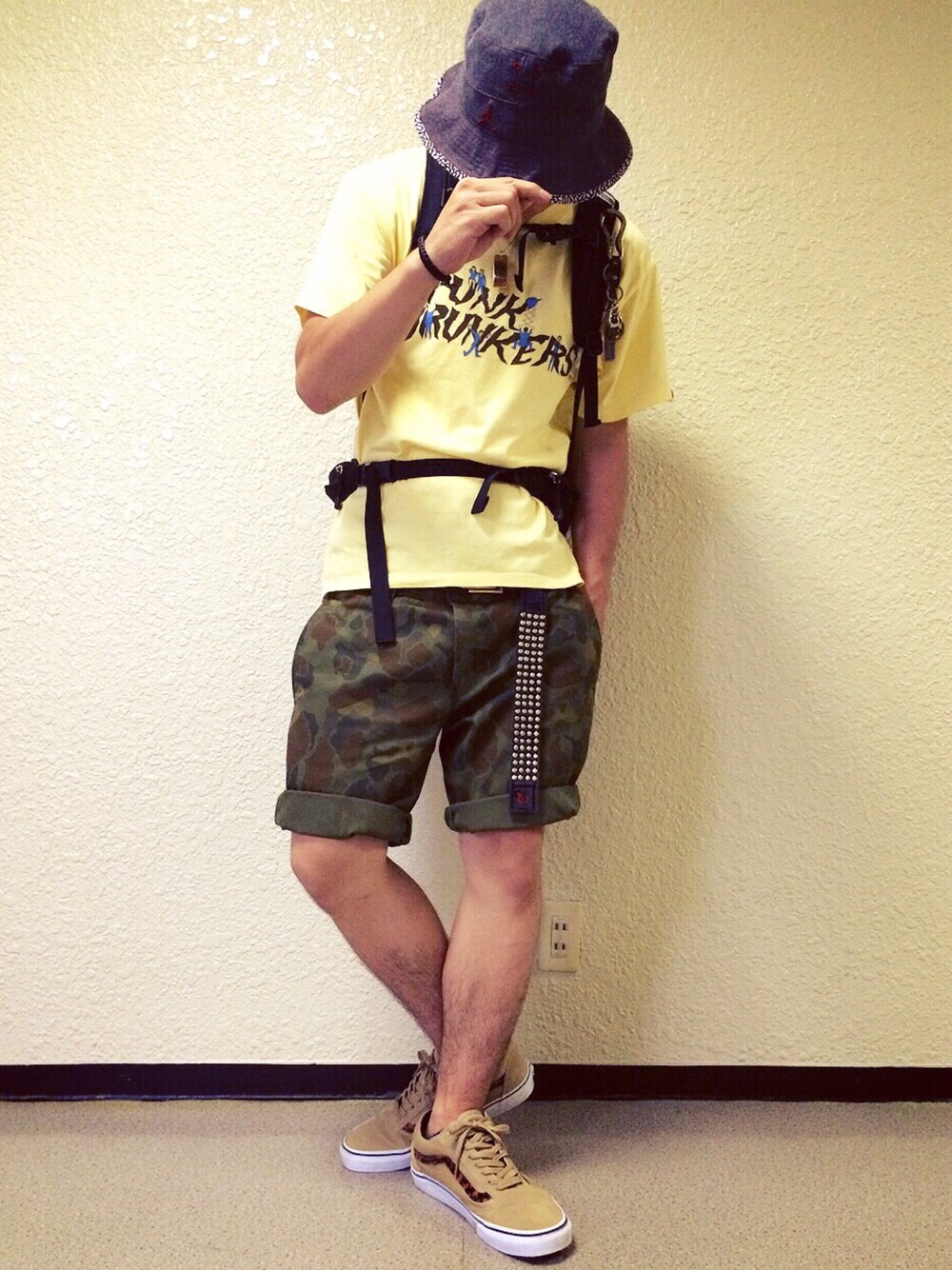 イエロー系のTシャツ/カットソー、ベージュ系のスニーカー、ブラック系のバックパック/リュックを着用したメンズの夏コーディネートの1枚目の写真