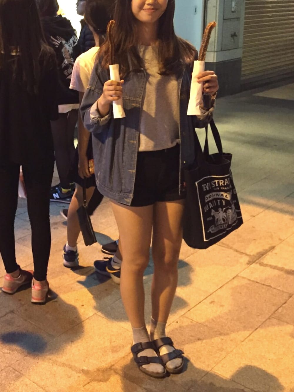 ブルー系のシューズ、ブラック系のハンドバッグ、グレー系のTシャツ/カットソーを着用したレディースの春コーディネートの1枚目の写真