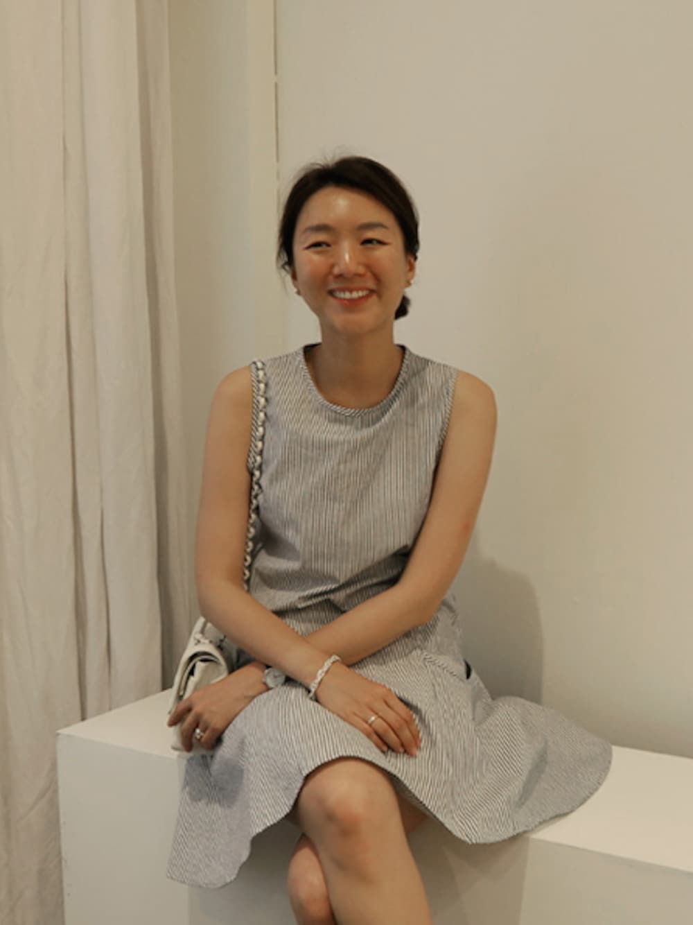 グレー系のワンピース、シルバー系のアンクレット、ホワイト系のピアス(両耳用)を着用したレディースの夏コーディネートの1枚目の写真