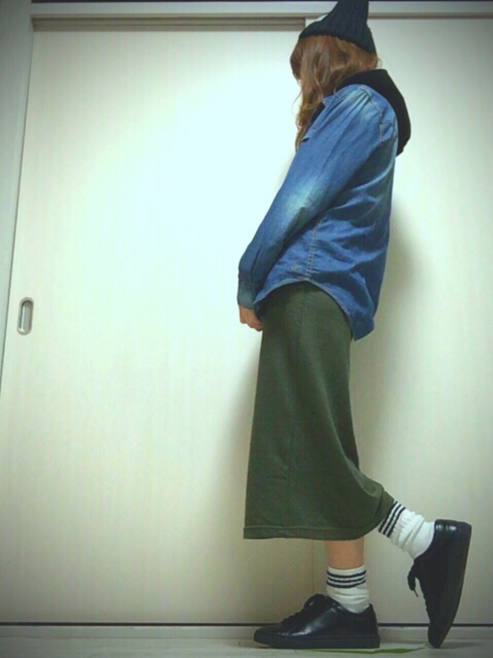 ブラック系のスニーカー、グリーン系のスカート、ブルー系のシャツ/ブラウスを着用したレディースの冬コーディネートの1枚目の写真