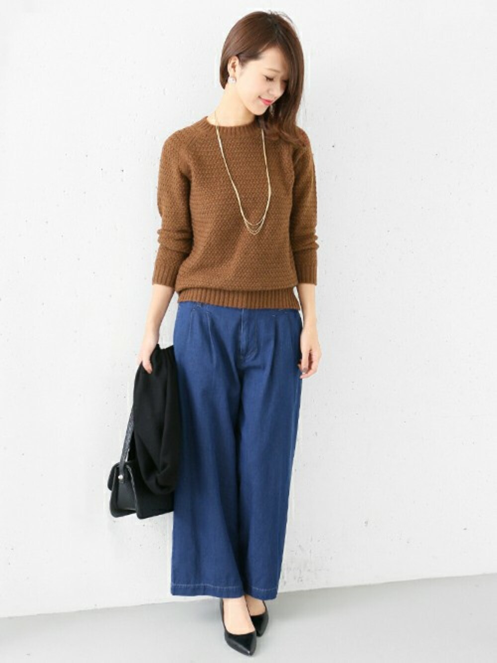 ブラウン系のニット/セーターを着用したレディースの冬コーディネートの1枚目の写真