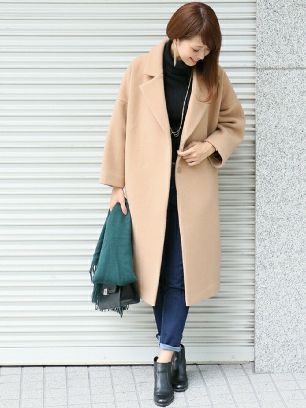 イエロー系のチェスターコート、ブルー系のデニムパンツを着用したレディースの秋コーディネートの1枚目の写真