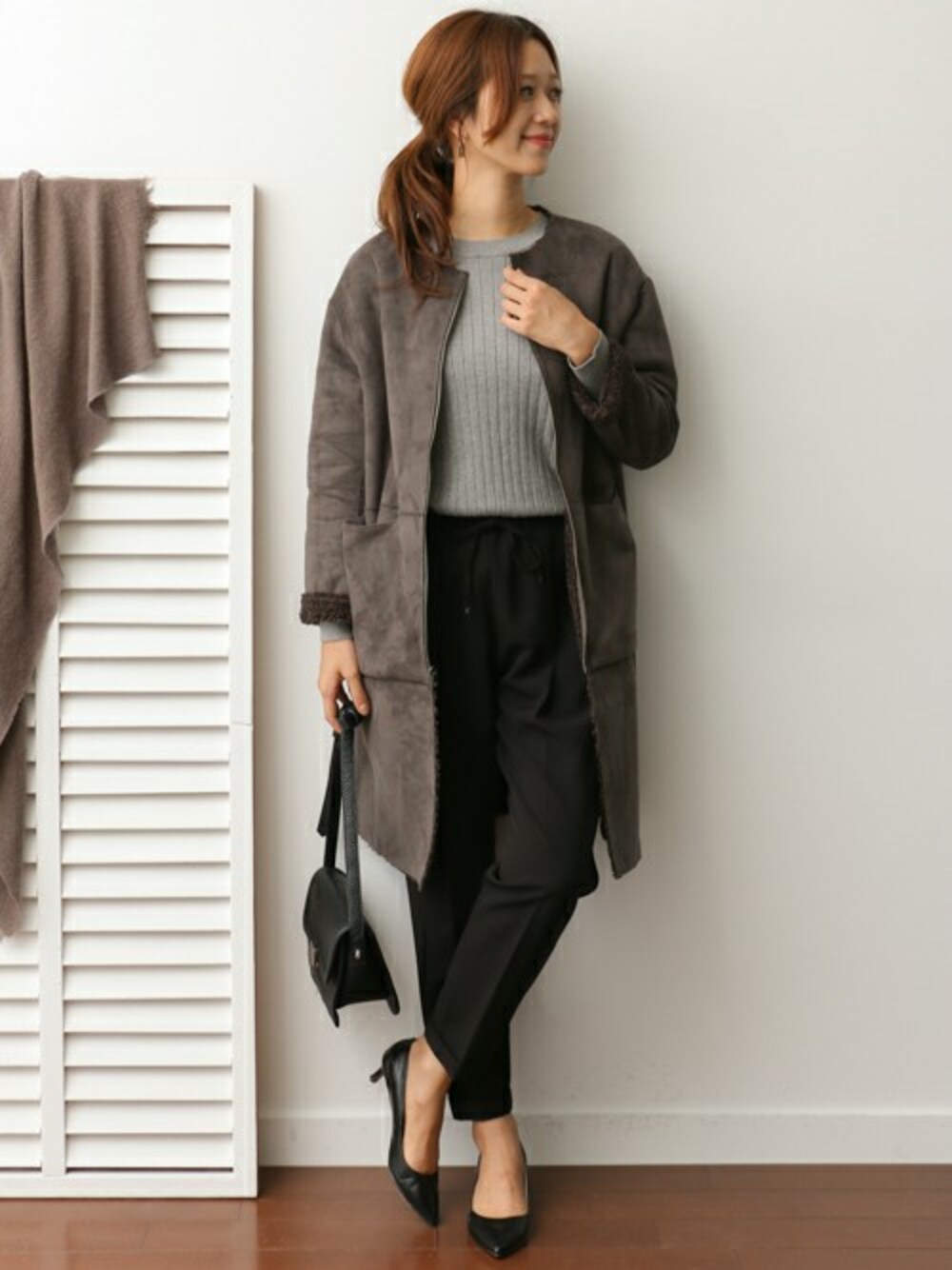 グレー系のムートンコート、グレー系のニット/セーター、ブラック系のその他パンツを着用したレディースの秋コーディネートの1枚目の写真